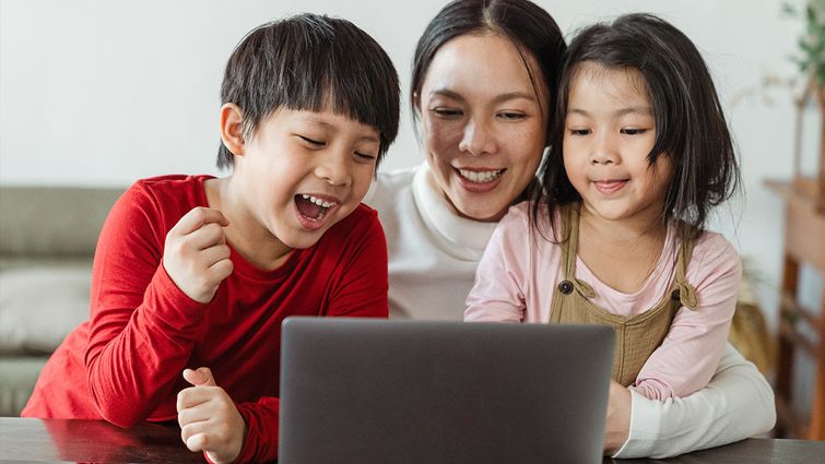 family of 3 looking at a laptop