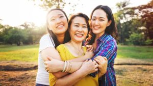 2 sisters and mom hugging