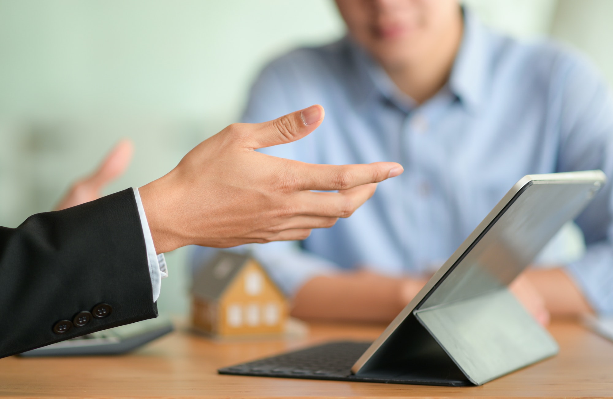 Close-up shot of Insurance broker is introducing a health insurance program with his tablet.