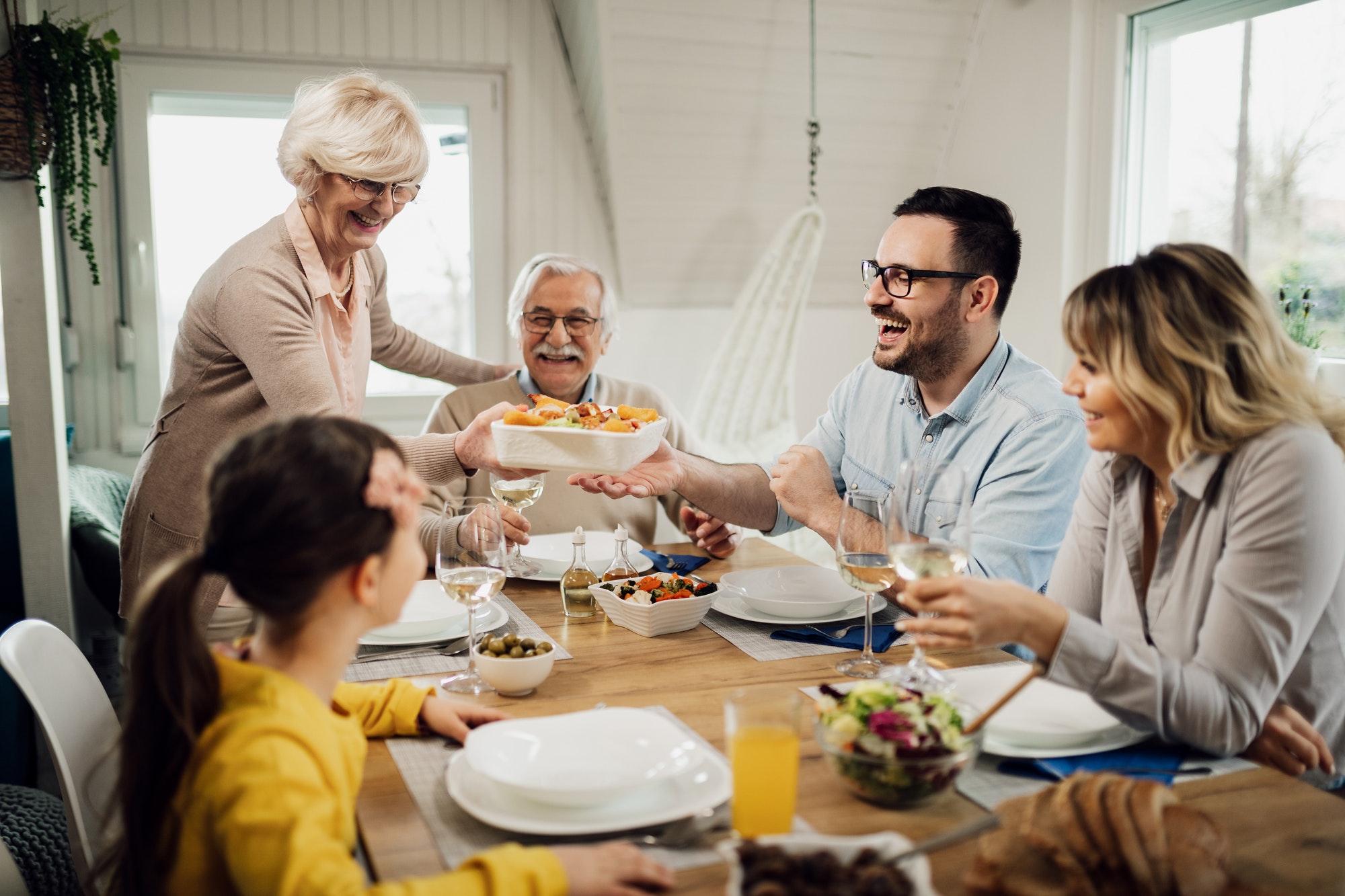 Happy extended family enjoying in lunch at dining table.