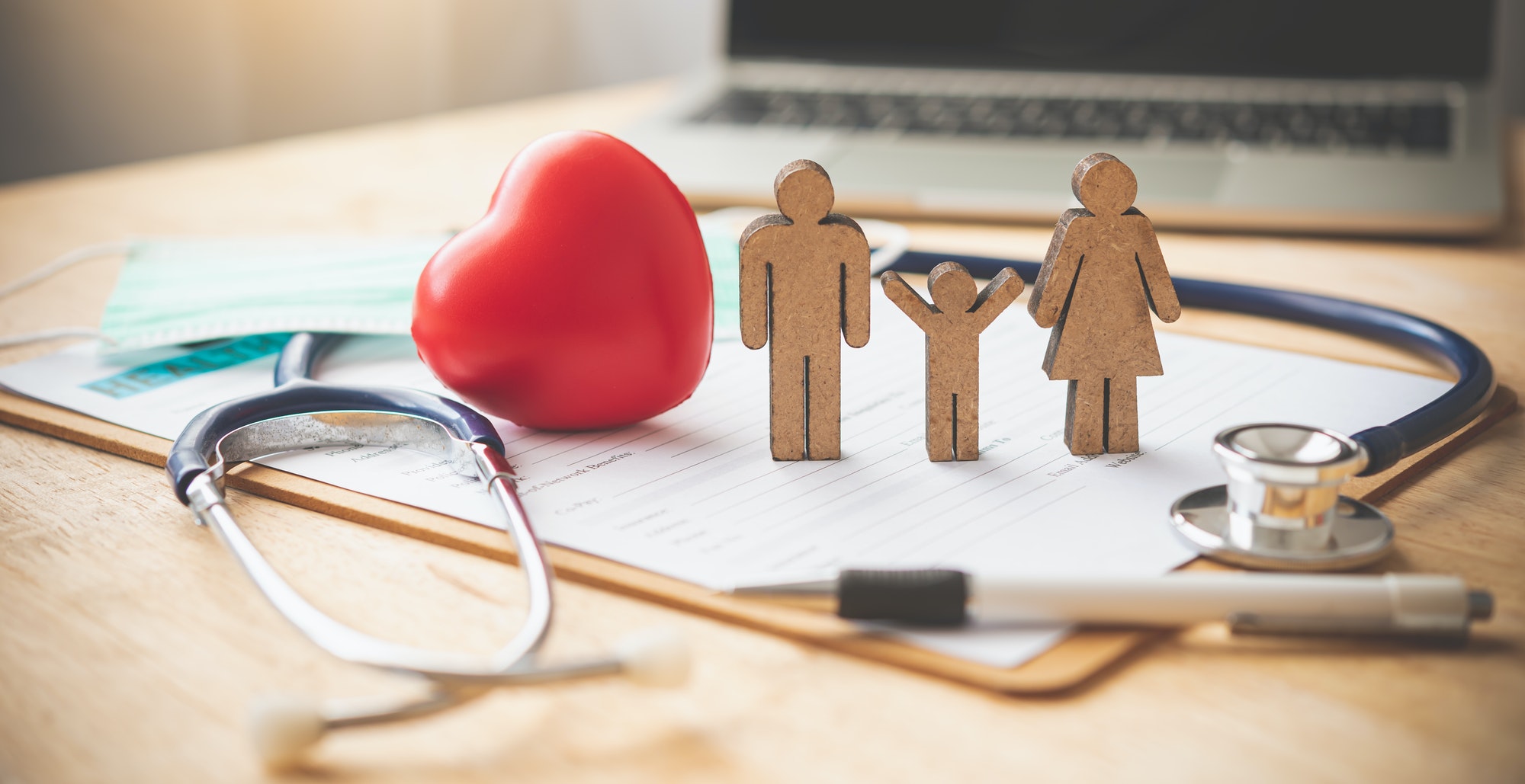 Medical Insurance Concept With Family And Stethoscope On Wooden Desk