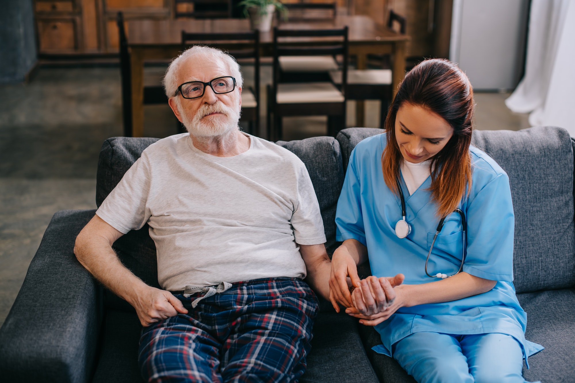 Medical worker checking heartbeat of senior man