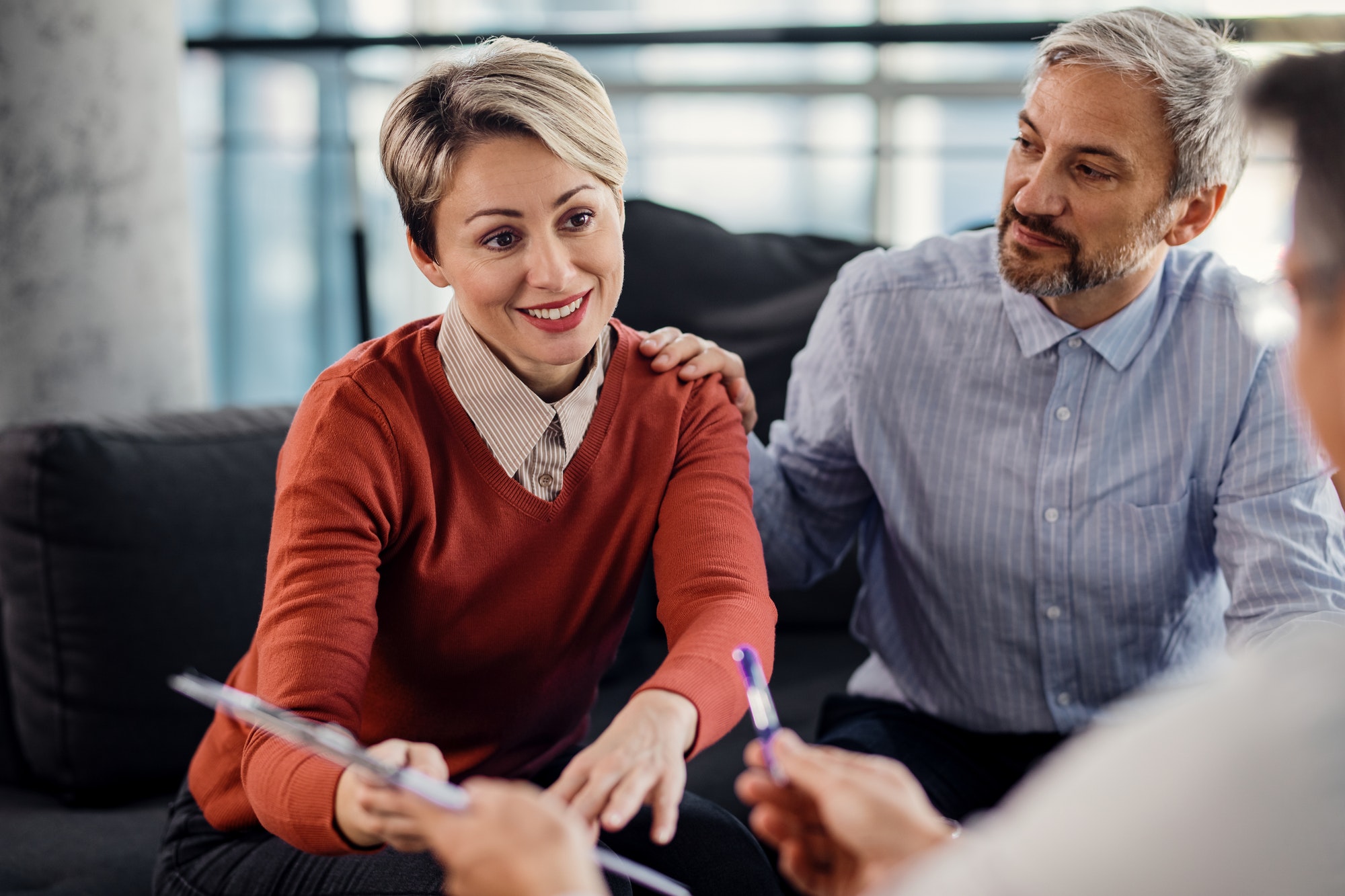 Mid adult couple making an agreement with their insurance agent on a meeting in the office.