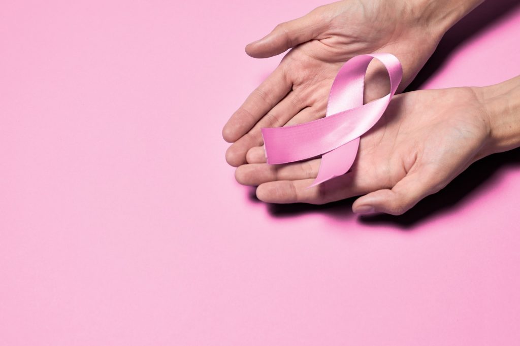 Hands hold pink ribbon, breast cancer concept, breast cancer awareness, breast cancer day, october.