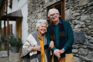 Happy senior couple posing near old countryside house.