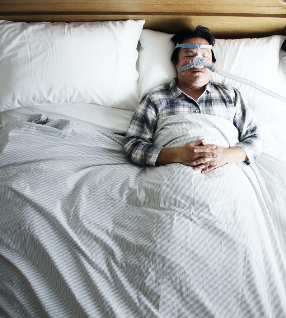 Man sleeping with an anti-snoring mask