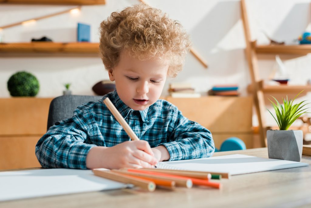 selective focus of kid drawing at desk