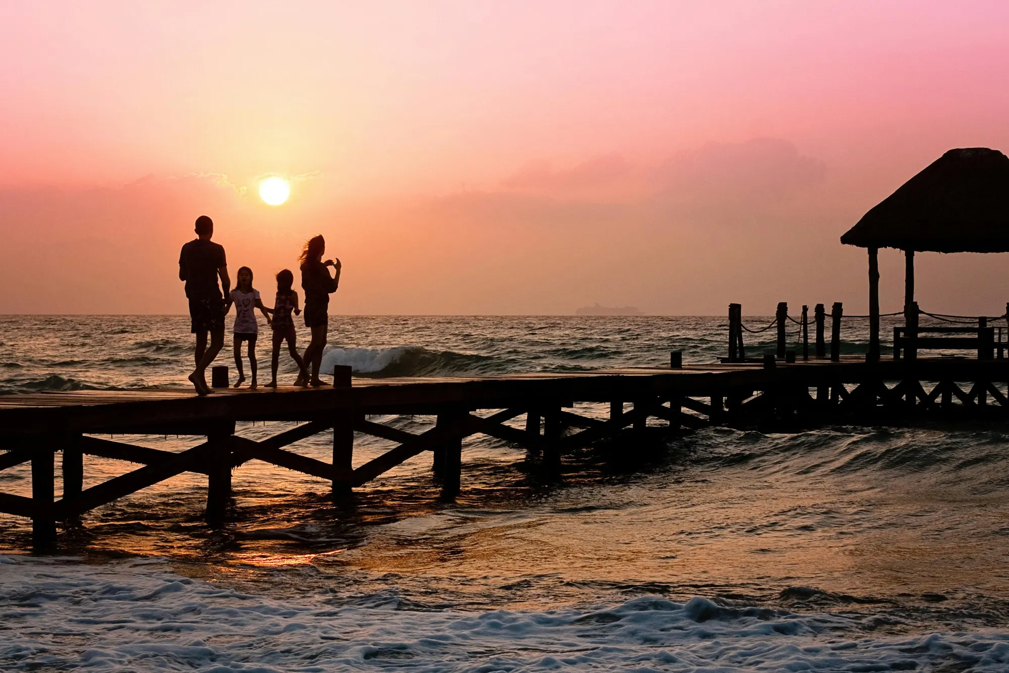 family of 4 on a pier at sunset
