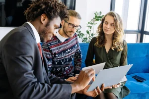 man in suit and couple looking at insurance documents