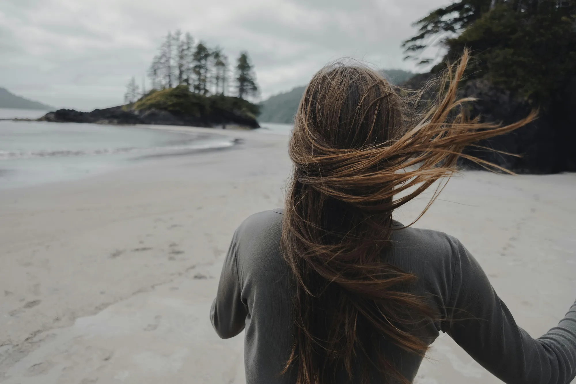 person running down the beach on the west coast of Canada